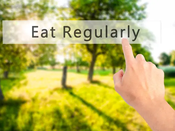 Eat Regularly - Hand pressing a button on blurred background con — Stock Photo, Image