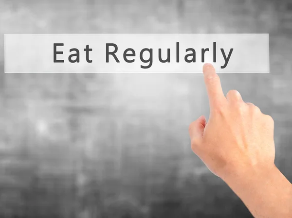 Eat Regularly - Hand pressing a button on blurred background con — Stock Photo, Image