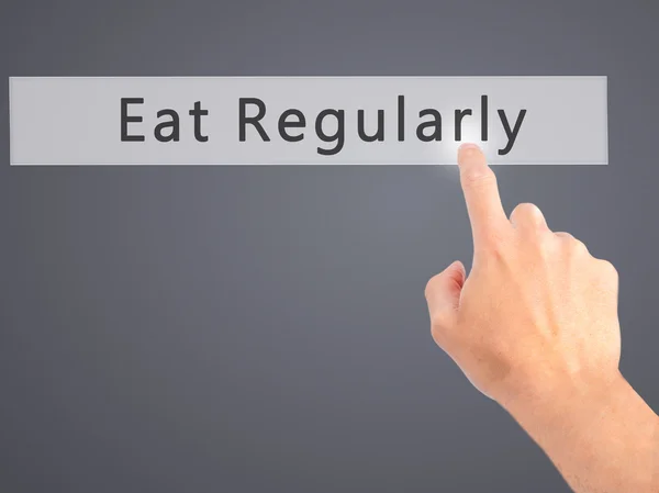 Regelmäßig essen - Hand auf Knopfdruck auf verschwommenem Hintergrund — Stockfoto
