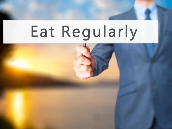 Egyél rendszeresen-üzletember kéztartó jel — Stock Fotó