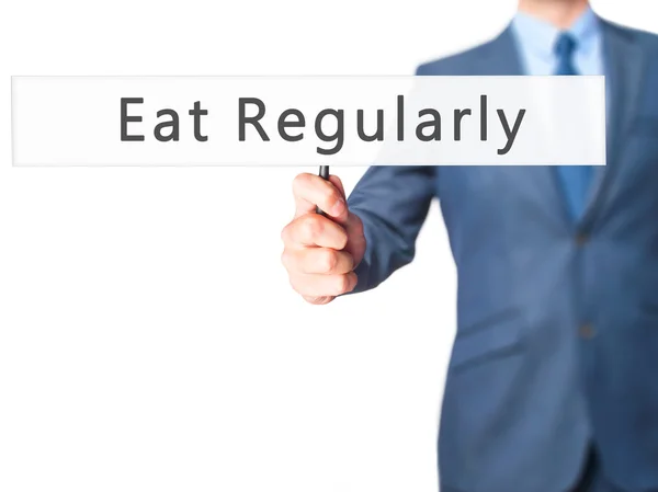 Eat Regularly - Businessman hand holding sign — Stock Photo, Image