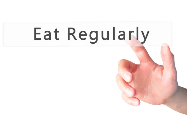 Mangiare regolarmente - Mano premendo un pulsante su sfondo sfocato con — Foto Stock