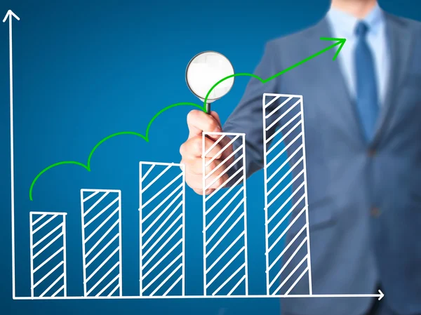 Gráfico de crecimiento de ventas - Hombre de negocios sosteniendo lupa en sc —  Fotos de Stock