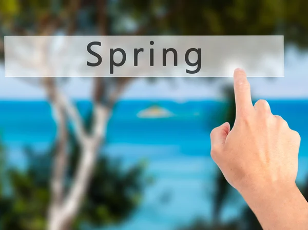 Tavasz - kéz egy elmosódott háttér koncepció gomb lenyomásával — Stock Fotó