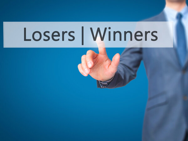 Winners  Losers - Businessman hand pressing button on touch scre