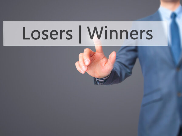 Winners  Losers - Businessman hand pressing button on touch scre