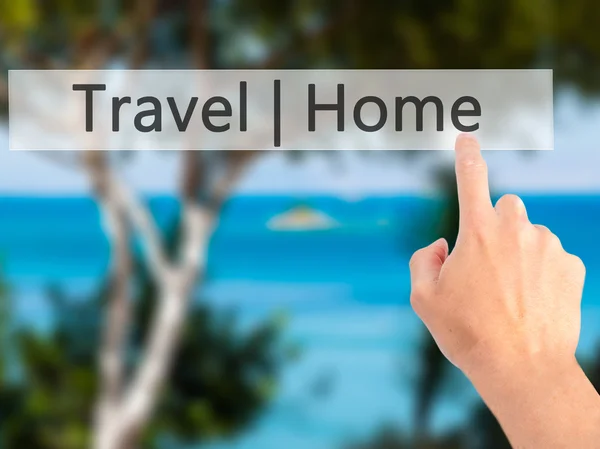 Travel  Home - Hand pressing a button on blurred background conc — Stock Photo, Image