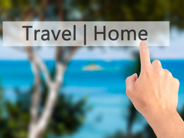Travel Home - Hand pressing a button on blurred background concept . Business, technology, internet concept. Stock Photo