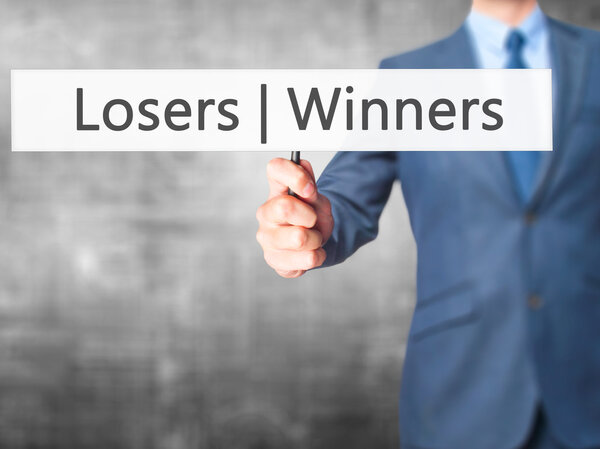 Winners  Losers - Businessman hand holding sign