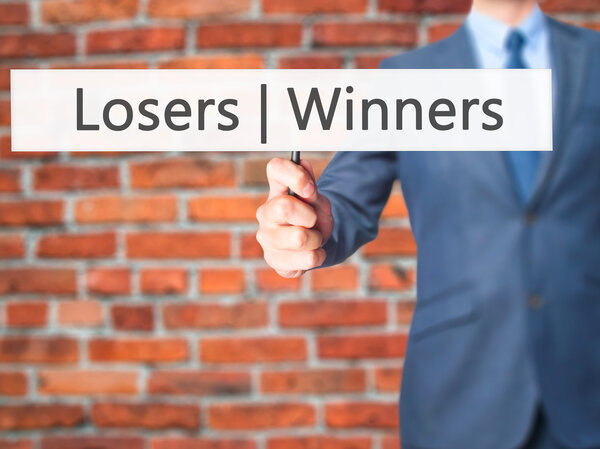 Winners  Losers - Businessman hand holding sign