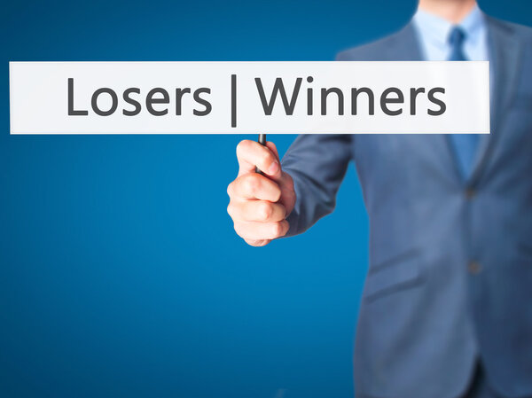 Winners  Losers - Businessman hand holding sign