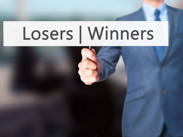 Winners  Losers - Businessman hand holding sign