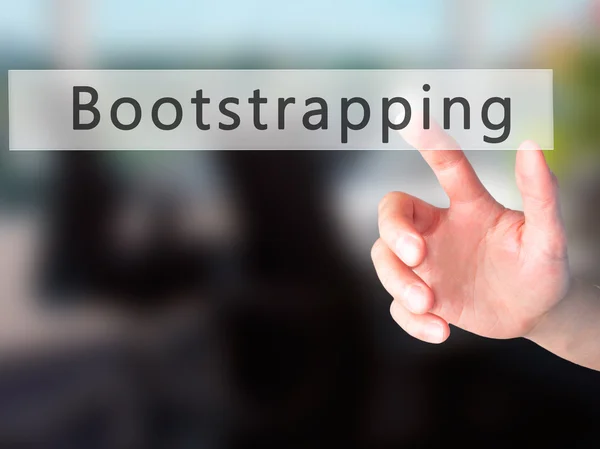 Bootstrapping - Mão pressionando um botão no fundo borrado con — Fotografia de Stock