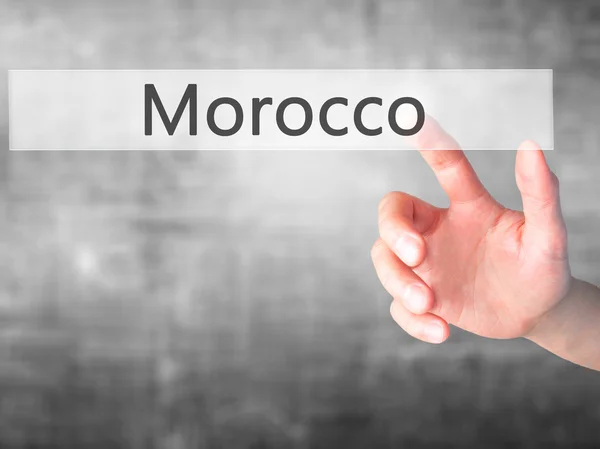 Marokkó - kéz egy gombnyomásra elmosódott háttér koncepció — Stock Fotó
