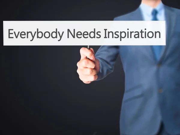 Everybody Needs Inspiration - Businessman hand holding sign — Stock Photo, Image