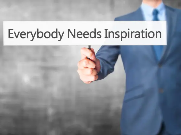 Everybody Needs Inspiration - Businessman hand holding sign — Stock Photo, Image