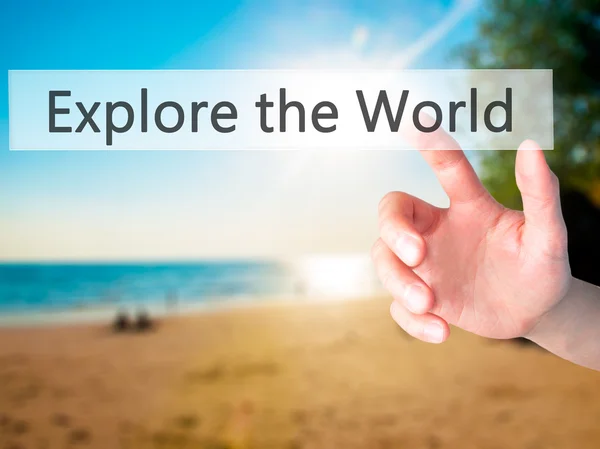 Explore the World - Hand pressing a button on blurred background — Stock Photo, Image