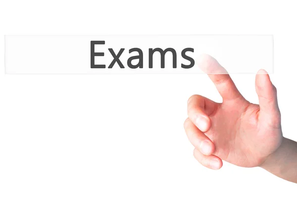 Exams - Hand pressing a button on blurred background concept on — Stock Photo, Image