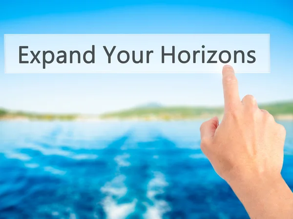 Expand Your Horizons - Hand pressing a button on blurred backgro — Stock Photo, Image