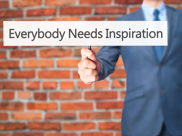 Everybody Needs Inspiration - Businessman hand holding sign — Stock Photo, Image