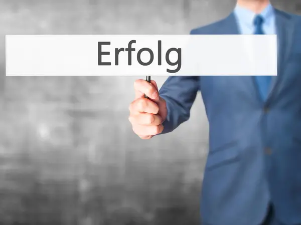 Erfolg (erfolg) - Geschäftsmann hält Schild in der Hand — Stockfoto