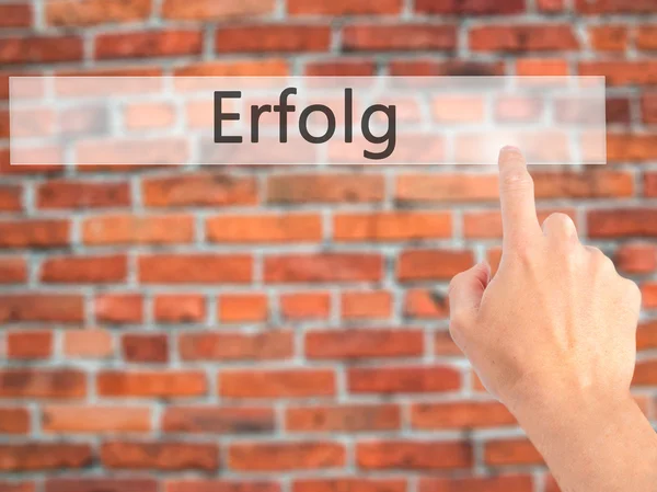 Erfolg (succes)-met de hand op een knop op een onscherpe achtergrond drukken — Stockfoto