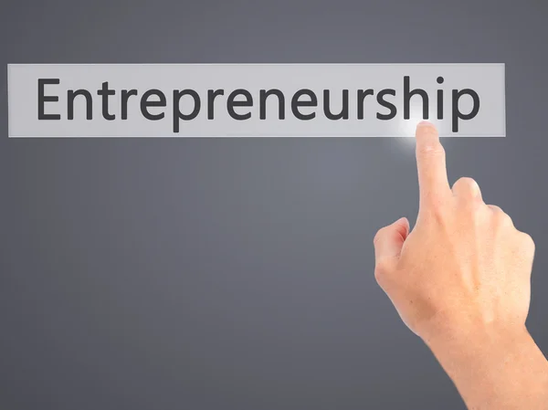Entrepreneurship - Hand pressing a button on blurred background — Stock Photo, Image