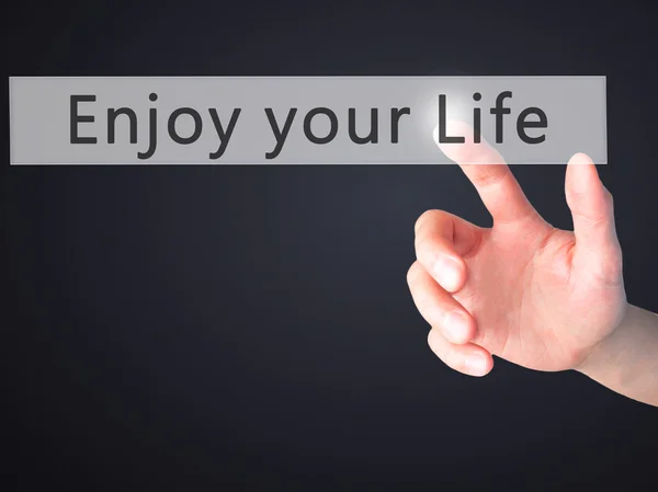 Njut av ditt liv - Hand trycka på en knapp på suddig bakgrund c — Stockfoto