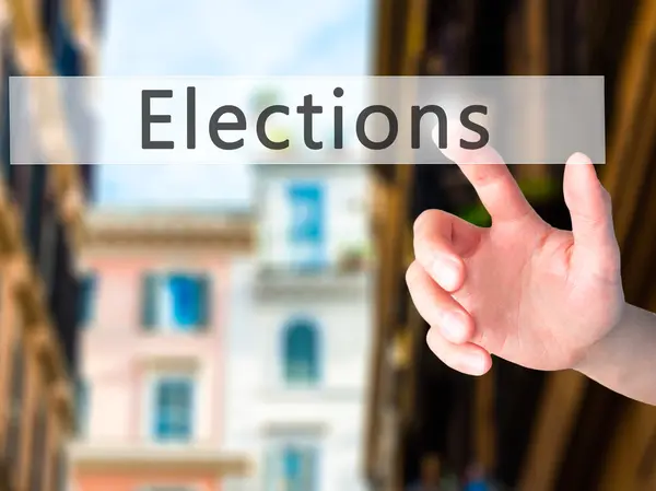 Wahlen - Hand auf Knopfdruck auf verschwommenes Hintergrundkonzept — Stockfoto