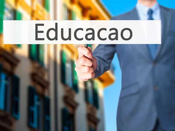 Educación (Educacao en portugués) - Empresario de la mano que sostiene si —  Fotos de Stock