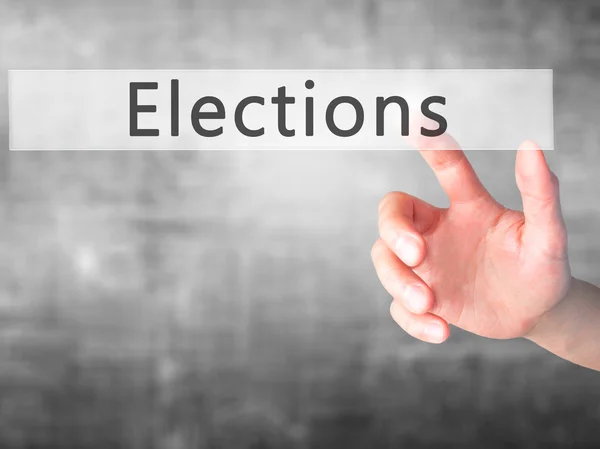 Elections - Hand pressing a button on blurred background concept — Stock Photo, Image