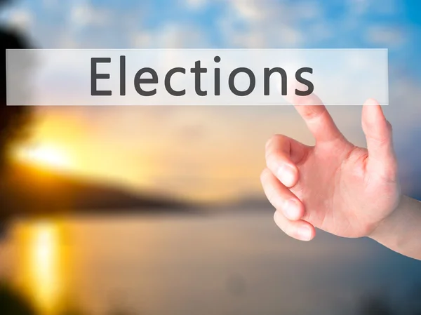 Választások - kéz egy gombnyomásra elmosódott háttér koncepció — Stock Fotó