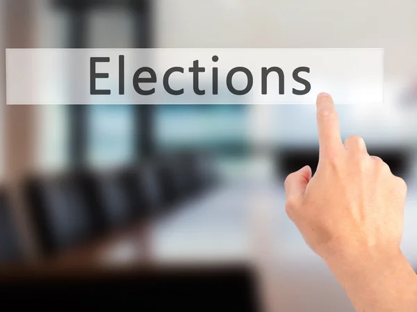 Elections - Hand pressing a button on blurred background concept — Stock Photo, Image