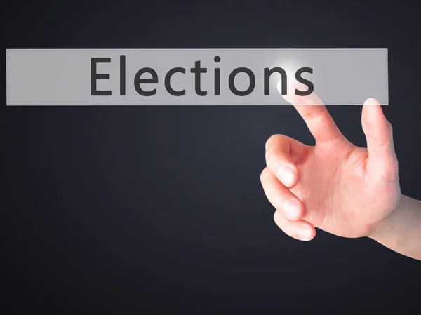 Verkiezingen - Hand indrukken van een knop op onscherpe achtergrond concept — Stockfoto