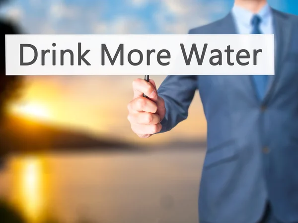 Pić więcej wody - biznesmen ręka trzyma znak — Zdjęcie stockowe