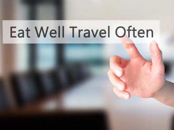 Eat Well Travel Often - Hand pressing a button on blurred backgr — Stock Photo, Image