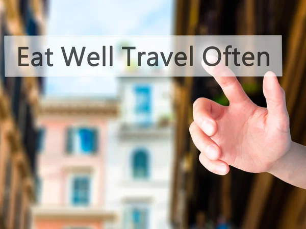 Eat Well Travel Often - Hand pressing a button on blurred backgr — Stock Photo, Image