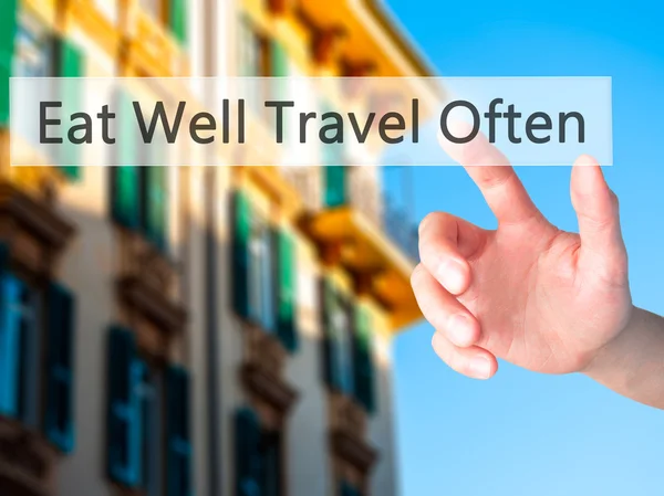 Eat Well Travel Often - Hand pressing a button on blurred backgr — Stock Photo, Image