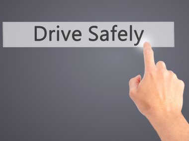 Drive Safely - Hand pressing a button on blurred background conc clipart