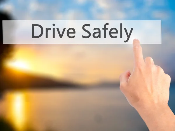 Drive Safely - Hand pressing a button on blurred background conc — Stock Photo, Image