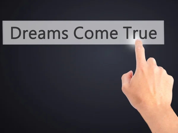 Dreams Come True - Hand pressing a button on blurred background — Stock Photo, Image