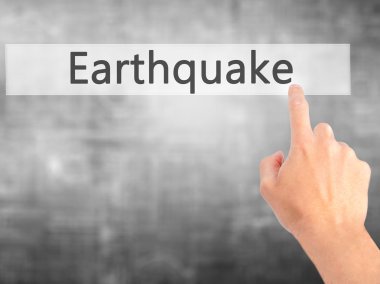Deprem - arka plan bulanık concep üzerinde bir düğmeye basarak el