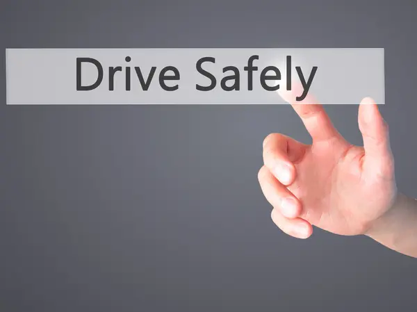 Drive Safely - Hand pressing a button on blurred background conc — Stock Photo, Image