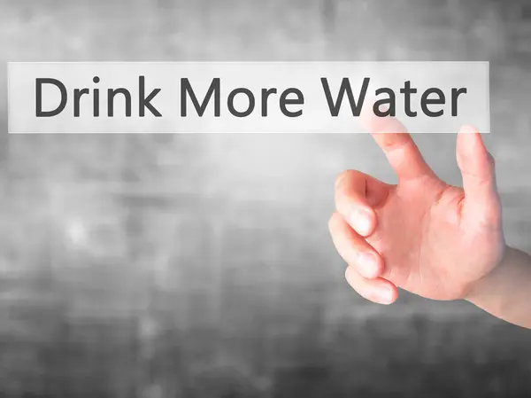 Пейте больше воды - вручную нажмите кнопку на размытом фоне — стоковое фото