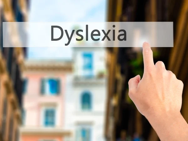 Dyslexie - Hand indrukken van een knop op onscherpe achtergrond concept — Stockfoto