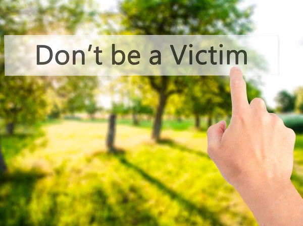 Don't be a Victim - Hand pressing a button on blurred background — Stock Photo, Image