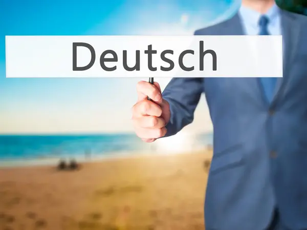 Deutsh (немецкий) - Бизнесмен, держащий в руках знак — стоковое фото