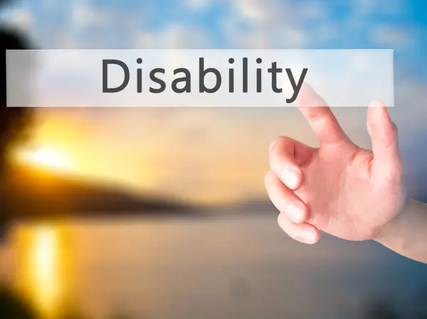 Инвалидность - Ручное нажатие кнопки на размытом фоне концепции — стоковое фото