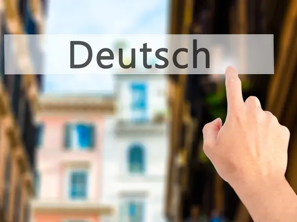 Deutsh (tyska på tyska) - Hand trycka på en knapp på suddiga ba — Stockfoto