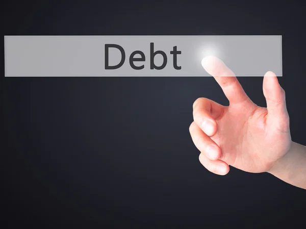 Debt - Hand pressing a button on blurred background concept on v — Stock Photo, Image